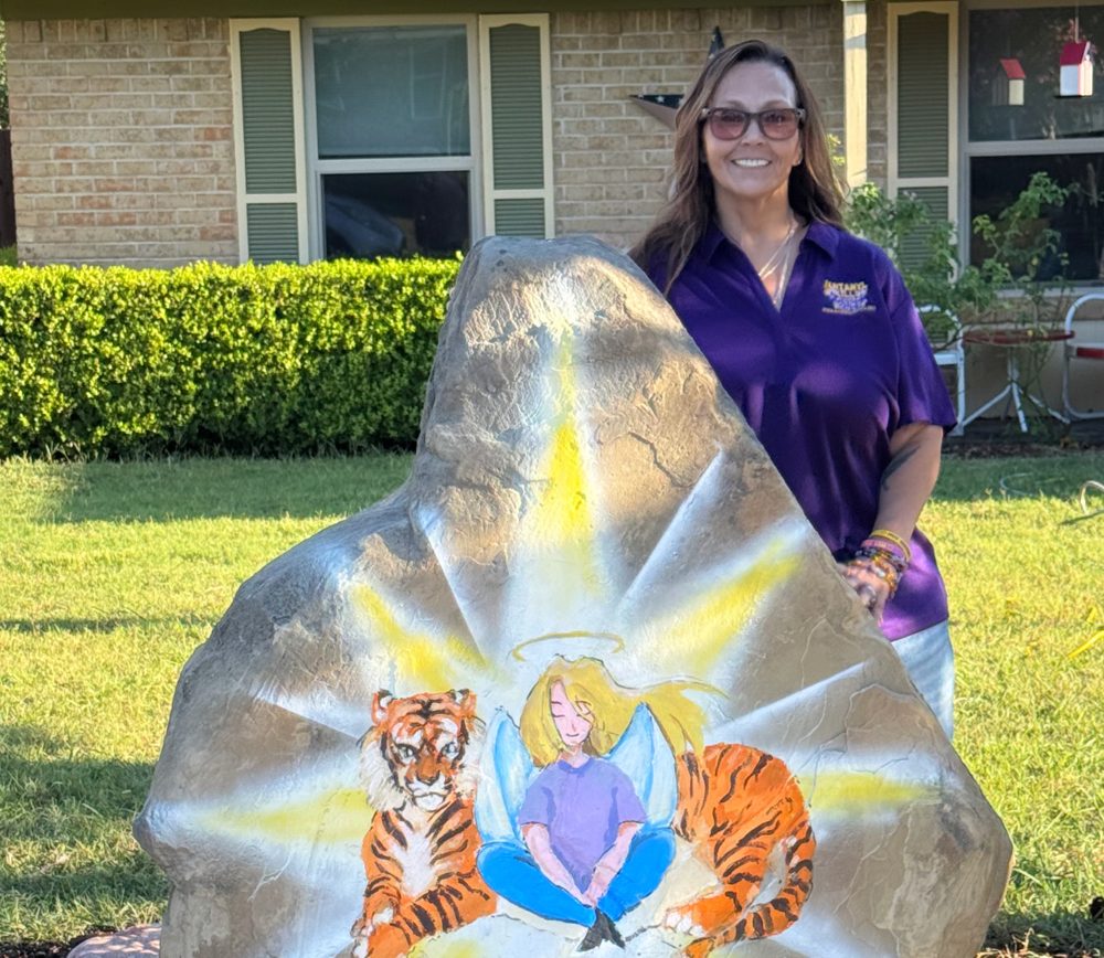 Amy standing beside the painted memorial boulder